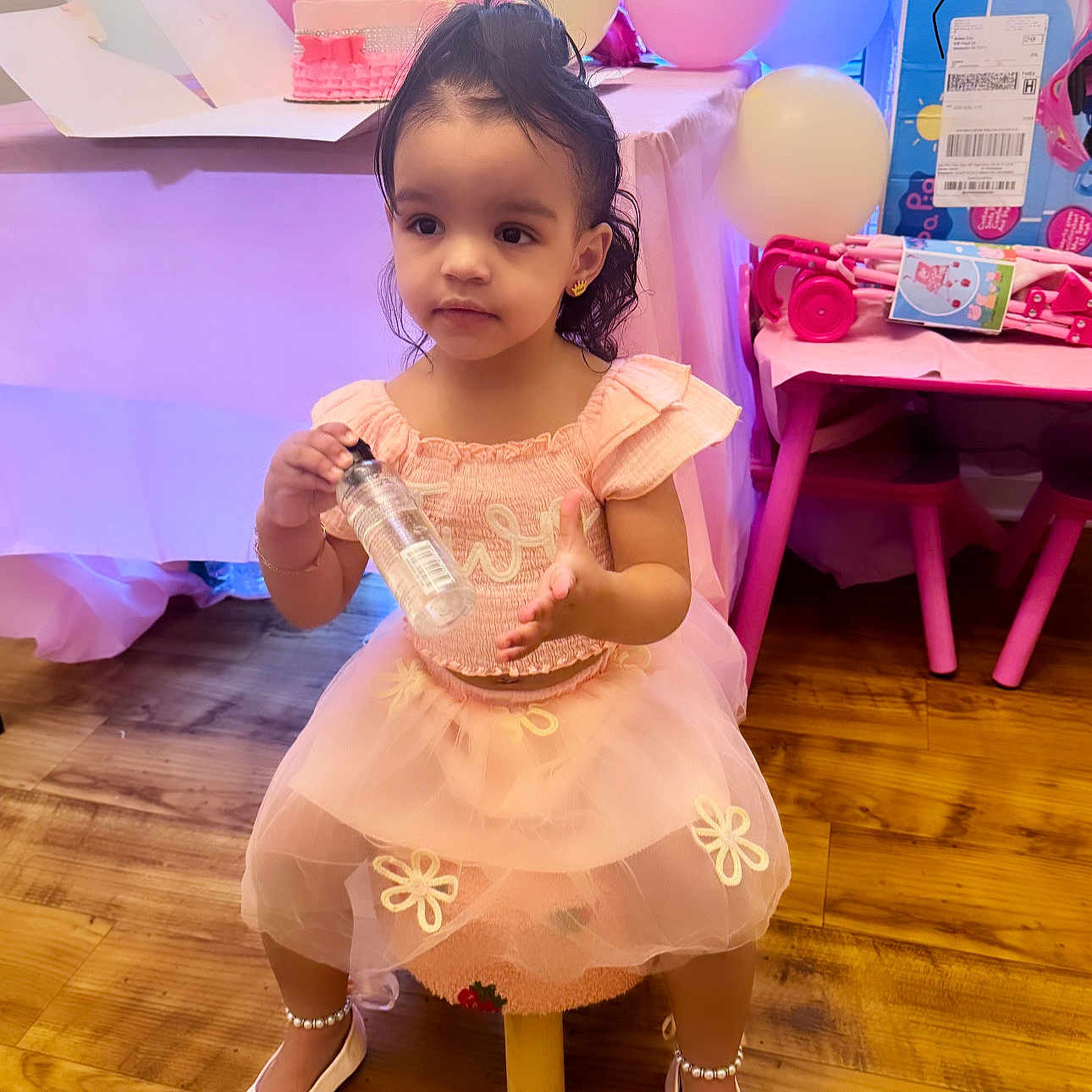Makayla Gisela is registered to the contest to win money with this photo: balloons, birthday, cake, celebration, chair, child, cute, face, floor, girl, happy, indoors, party, pearl_anklet, pink_dress, shoes, small_stool, table, toy, wood_floor