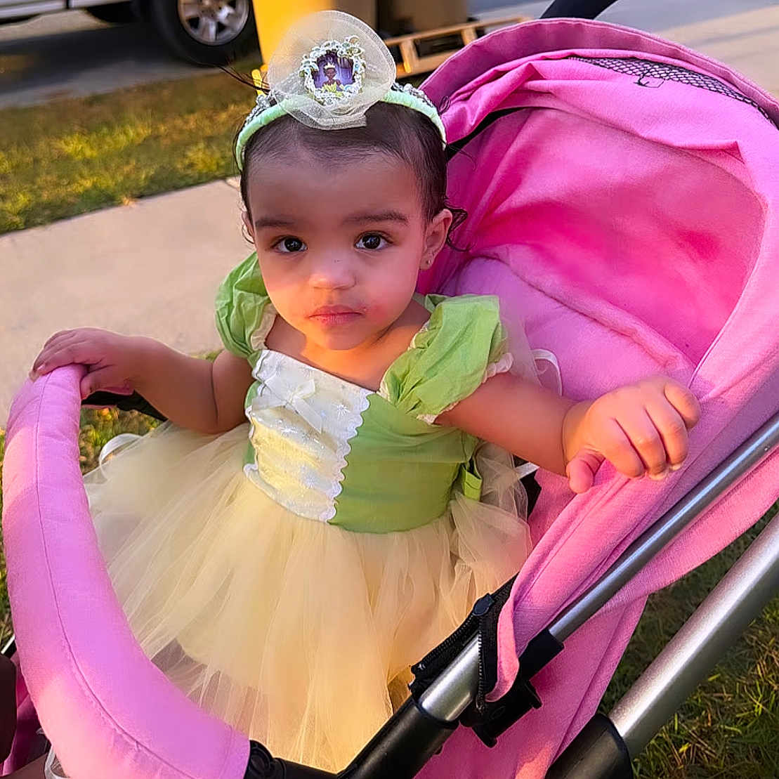 Makayla joined the competition — help win amazing prizes! accessories, baby, car, clothing, dress, face, grass, happy, head, jewelry, person, photography, plant, portrait, sitting, smile, stroller, sunglasses, transportation, vehicle