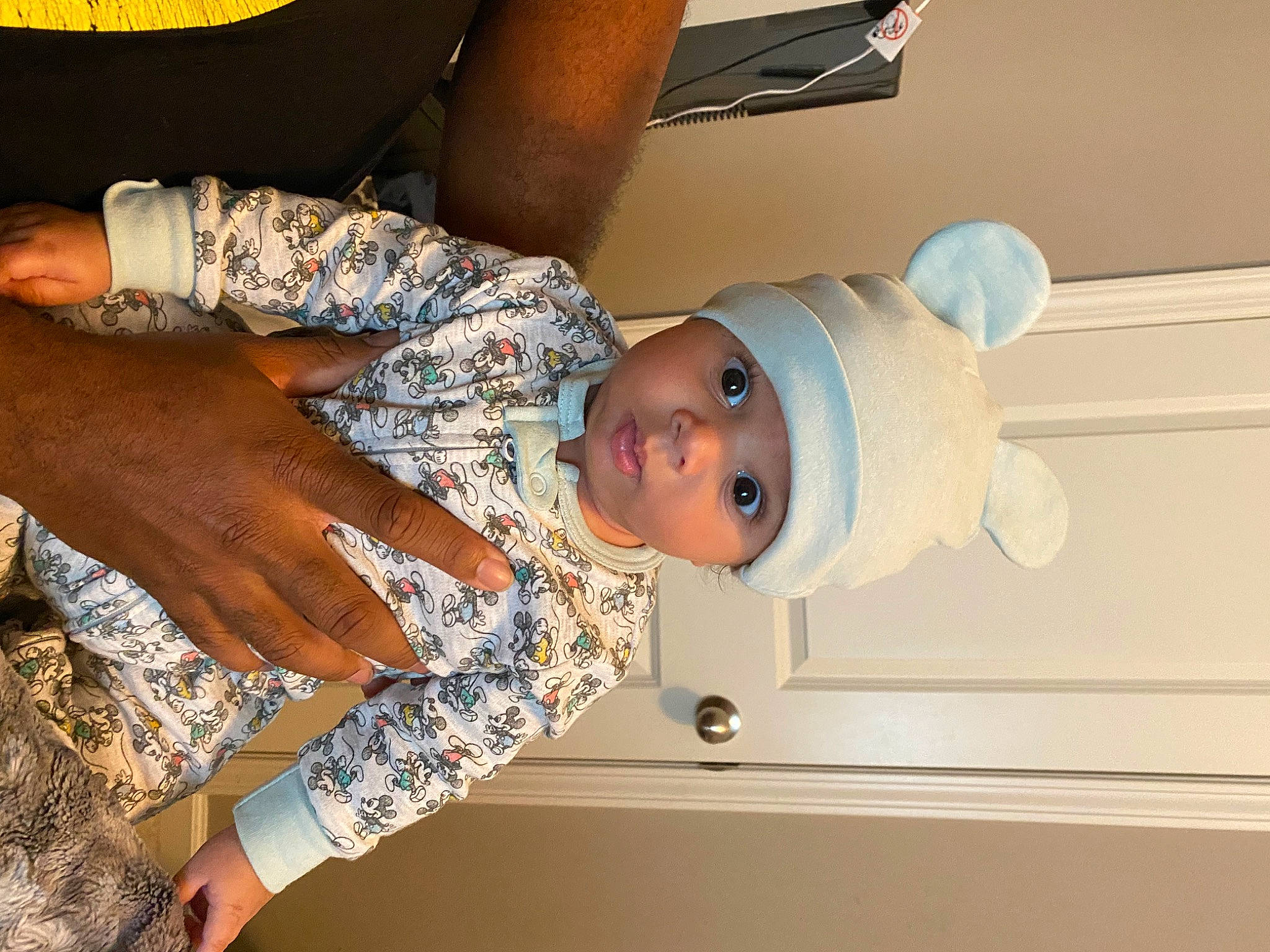 Julius is registered to the contest to win money with this photo: arm, baby, baby_products, baby_toddler_clothing, chair, child, comfort, elbow, finger, fun, gesture, hand, hat, headwear, human_leg, nail, pattern, person, room, sleeve