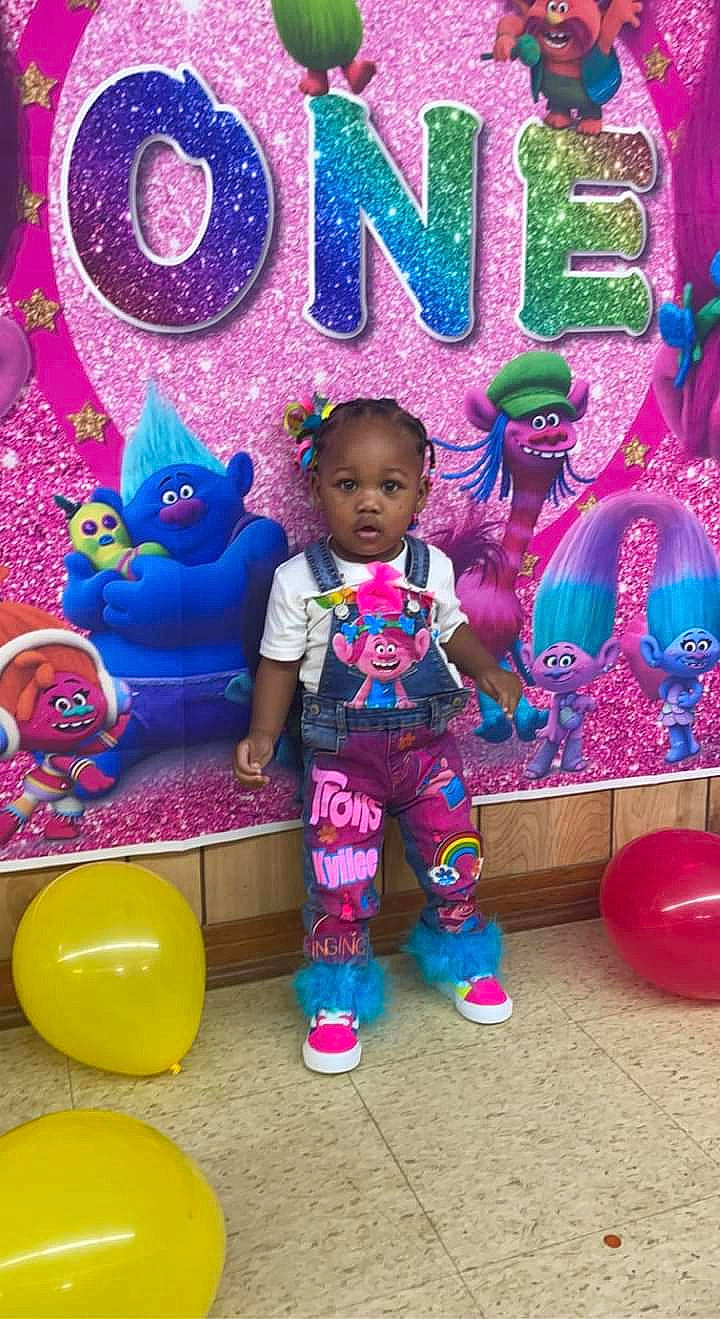 Kyilee is registered to the contest to win money with this photo: baby_toddler_clothing, blue, child, event, fun, happy, leisure, magenta, mammal, party_supply, person, pink, play, product, purple, red, t_shirt, toddler, toy, violet