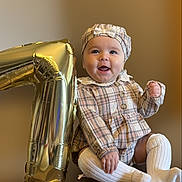 Azalea joined the competition — help win amazing prizes! baby, child, plaid_clothing, hat, white_socks, balloon, number_one, celebration, smile, happy, portrait, sitting, cute, infant, first_birthday, indoors, baby_girl, clothing, face, headwear