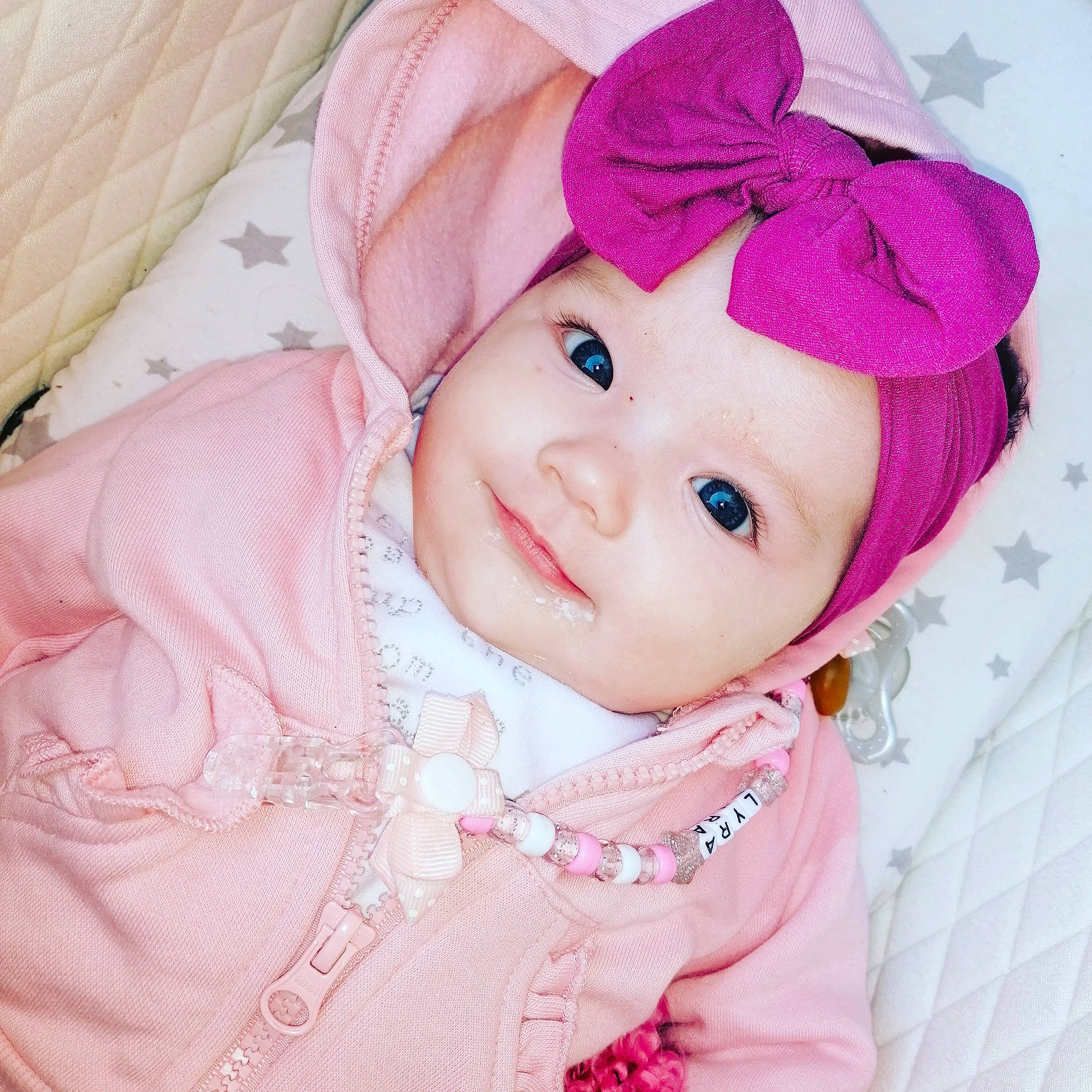 Lyra is registered to the contest to win money with this photo: baby, baby_toddler_clothing, cap, cheek, clothing, collar, creative_arts, face, happy, headgear, headwear, lip, magenta, outerwear, person, pink, skin, sleeve, smile, sun_hat