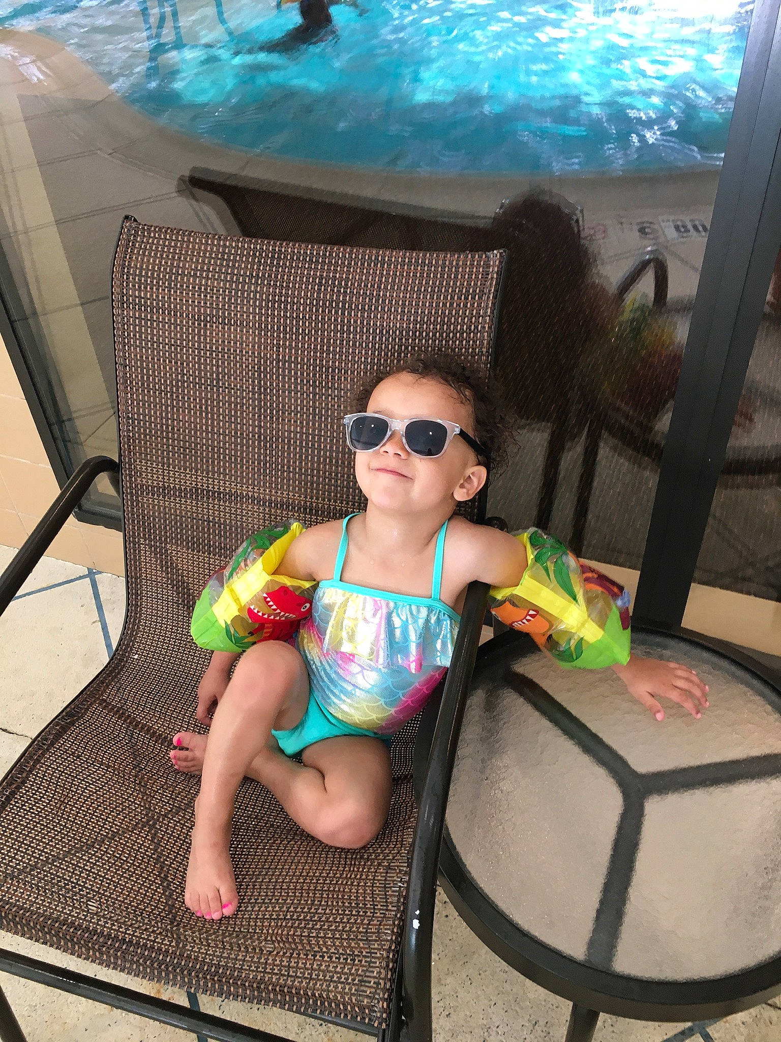 Egypt is registered to the contest to win money with this photo: baby_toddler_clothing, blue, eyewear, foot, fun, glasses, goggles, green, joy, leisure, outdoor_furniture, person, personal_protective_equipment, photograph, recreation, summer, sunglasses, swimming_pool, swimwear, thigh