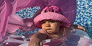 Leewene a rejoint le concours — aidez-le/la à gagner de superbes lots ! baby, pink_hat, inflatable_float, pool, water, sunlight, child, summer, outdoor, blue_sky, mosaic_tiles, green_tree, cute, reaching_hand, swimming, fun, vacation, sun_hat, infant, playful