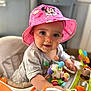 baby, child, pink_hat, minnie_mouse, toy, activity_center, indoor, smiling, face, person, play, colorful, cute, infant, clothing, seat, happy, hand, headwear, closeup