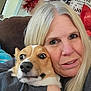 Millie is registered to the contest to win money with this photo: animal, blonde_hair, casual_clothing, closeup, corgi, couch, cozy, dog, face, holiday_decor, hugging, indoor, living_room, pet, portrait, santa_hat, smiling, surprised_expression, tinsel, woman