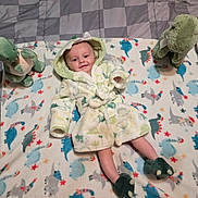 Asher joined the competition — help win amazing prizes! baby, child, dinosaur, robe, blanket, plush_toy, footwear, smile, pattern, bedspread, cute, indoor, soft_toy, infant, comfort, sleepwear, colorful, happy, lying_down, playful