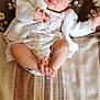 Elia participe au concours pour gagner de l'argent avec cette photo : baby, sleeping, infant, blanket, pillow, floral_pattern, white_sweater, dress, legs, toes, peaceful, indoors, soft_lighting, closeup, cute, child, resting, person, portrait, cozy