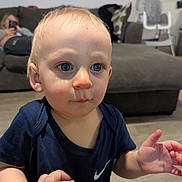 Hudson joined the competition — help win amazing prizes! toddler, child, blue_eyes, navy_shirt, hand, living_room, couch, woman, phone, high_chair, floor, person, indoors, curious_expression, baby, short_hair, skin, holding, background, casual