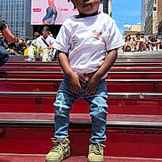 Keith is registered to the contest to win money with this photo: child, urban, city, steps, red, casual_clothing, jeans, tshirt, sneakers, people, buildings, advertisement, daytime, sky, outdoor, portrait, standing, crowd, street, casual