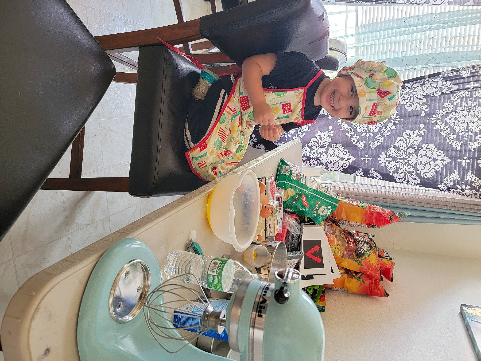 Jaxx is registered to the contest to win money with this photo: breakfast, chair, child, dishware, drinkware, eyewear, fedora, hat, headwear, joy, linens, major_appliance, person, plastic, plate, porcelain, room, sun_hat, table, tableware