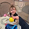 baby, child, playpen, toy, ball, smile, happy, indoor, mesh, bucket, clothing, person, floor, cute, sitting, hair, skin, infant, play, legs