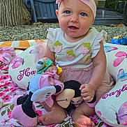 Hazley is registered to the contest to win money with this photo: baby, blanket, blue_eyes, child, cushion, cute, flower_pattern, grass, happy, headband, nature, outdoor, pink, playtime, portrait, sitting, smiling, stuffed_toy, toddler, toy