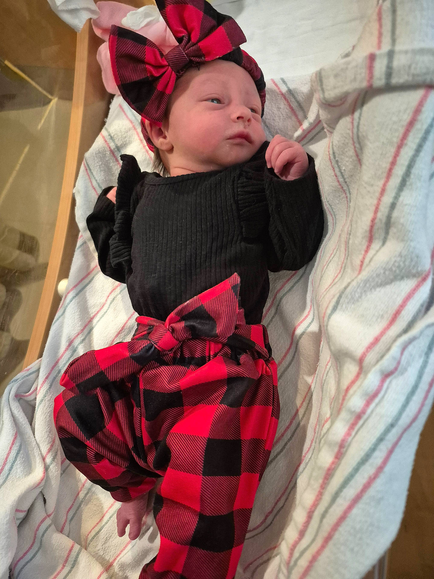 Hazley joined the competition — help win amazing prizes! baby, black_clothing, bow, child, comfortable, cozy, cute, headband, indoors, infant, lying_down, newborn, portrait, red_and_black_checkered, resting, sleepy_eyes, small_hands, soft_fabric, striped_blanket, warm