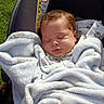 baby, blanket, car_seat, sleeping, outdoor, grass, infant, child, soft, cozy, peaceful, face, head, clothing, person, portrait, wrapped, nap, cute, young