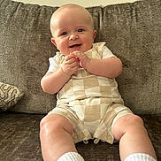 Cody joined the competition — help win amazing prizes! baby, smiling, sitting, couch, infant, child, happy, face, clothing, white_socks, beige_outfit, indoor, portrait, cute, young_child, plush, comfort, furniture, human, skin