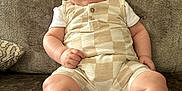 Cody joined the competition — help win amazing prizes! baby, child, smile, romper, socks, couch, indoor, portrait, happy, infant, seated, cute, person, face, skin, clothing, young_child, comfort, texture, relaxation