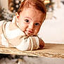 baby, infant, child, portrait, closeup, smile, eyes, cozy_clothing, striped_sweater, wooden_table, holiday, christmas_tree, bokeh, ornaments, warm_tones, cute, lying_down, indoors, soft_texture, festive