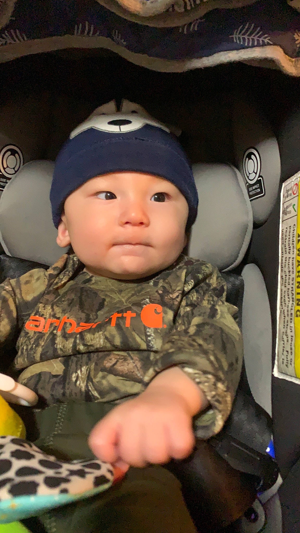 Abraham is registered to the contest to win money with this photo: auto_part, baby, baby_toddler_clothing, camouflage, cap, car_seat, child, comfort, cool, eye, face, finger, gesture, headgear, headwear, military_camouflage, military_uniform, person, sitting, sleeve