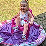 Maëlys participe au concours pour gagner de l'argent avec cette photo : child, toddler, smiling, pink_chair, kiddie_pool, purple, grass, outdoor, summer, sandals, dress, happy, playful, sunlight, young_child, person, small_pony_tail, colorful, casual_clothing, nature