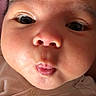 baby, face, close_up, expression, puckered_lips, chubby_cheeks, infant, skin, eyes, cute, portrait, child, newborn, soft_lighting, clothing, person, indoors, head, looking_at_camera, young