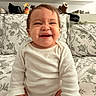 Jhaslyn joined the competition — help win amazing prizes! baby, child, smiling, happy, portrait, sitting, indoors, bedroom, bed, floral_bedding, white_clothing, onesie, shelves, shoes, footwear, home, infant, face, laughter, photography