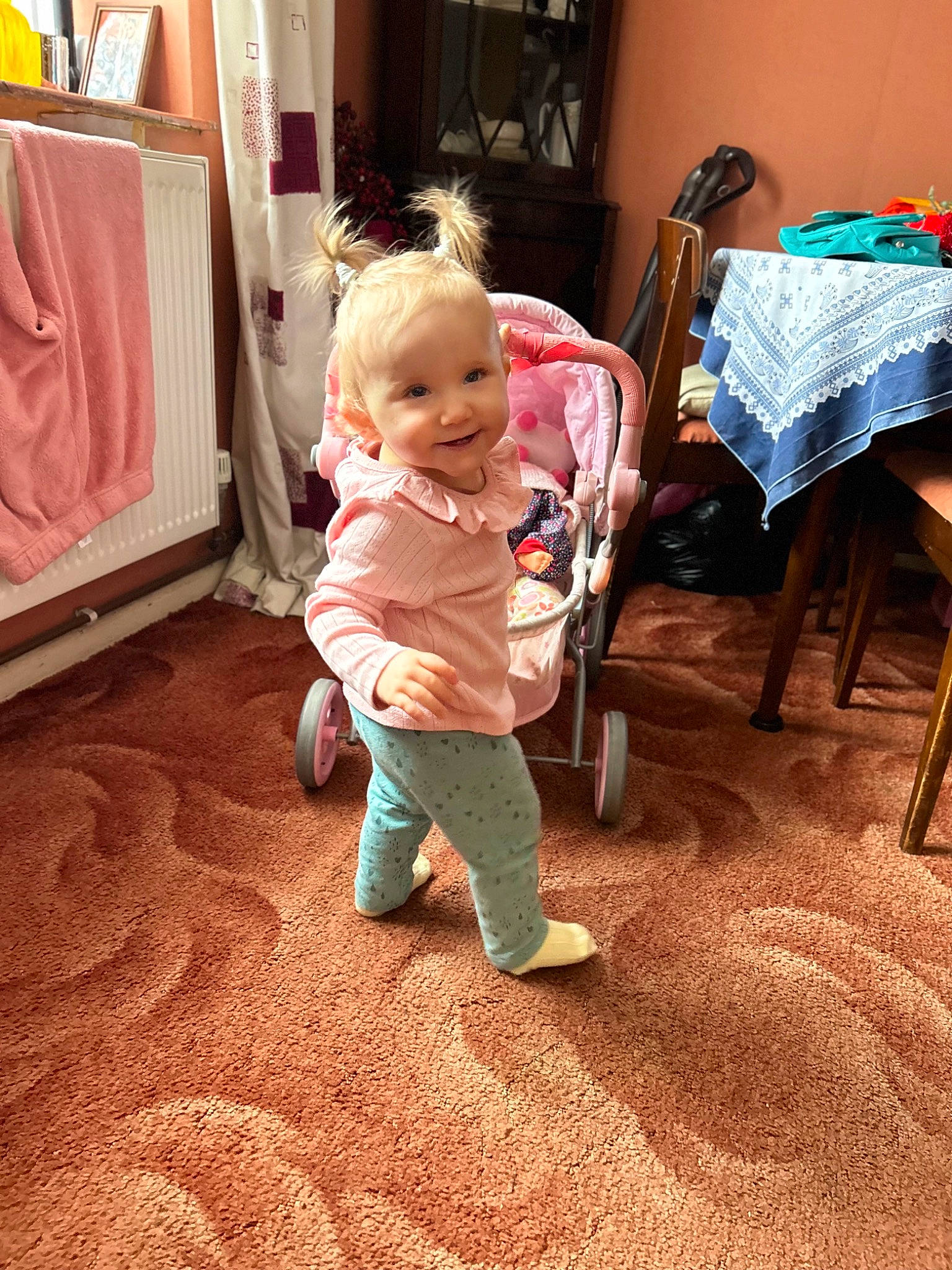 Maddie is registered to the contest to win money with this photo: baby, baby_toddler_clothing, carpet, child, comfort, floor, flooring, fun, hardwood, joy, living_room, person, play, room, sitting, sleeve, smile, standing, t_shirt, toddler