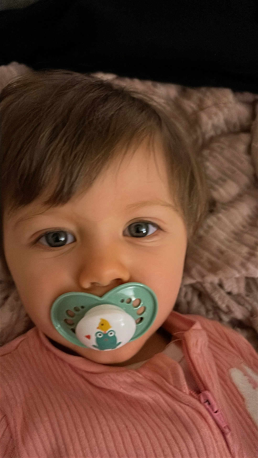 Selena a rejoint le concours — aidez-le/la à gagner de superbes lots ! baby, pacifier, child, face, eyes, pink_clothing, blanket, portrait, infant, cute, closeup, soft_texture, sleepwear, young_child, indoors, comfort, pacifier_design, toddler, resting, cozy