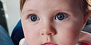 Selena participe au concours pour gagner de l'argent avec cette photo : baby, infant, face, blue_eyes, pink_bib, clothing, cute, child, portrait, closeup, soft_hair, indoor, person, skin, expression, gaze, hand, wooden_toy, white_shirt, adorable