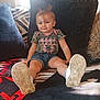 Lariah Ronda Dennis joined the competition — help win amazing prizes! toddler, child, smile, camo_shirt, denim_shorts, white_shoes, couch, patterned_blanket, remote_control, indoor, happy, sitting, face, feet, short_hair, blue_eyes, casual_clothing, living_room, plush_pillow, young_child