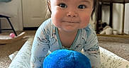 Neo is registered to the contest to win money with this photo: baby, child, infant, portrait, smiling, face, eyes, brown_hair, blue_eyes, onesie, plush_toy, octopus, toy, play_seat, cushion, indoor, living_room, furniture, carpet, happy