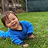 Neo is registered to the contest to win money with this photo: baby, child, smiling, outdoor, grass, lawn, blue_outfit, portrait, lying_down, happy, face, infant, garden, backyard, natural_light, short_hair, playful, greenery, close_up, photography