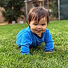 baby, child, crawling, outdoor, grass, lawn, blue_shirt, smiling, tongue_out, portrait, close_up, backyard, garden, greenery, daylight, face, brown_hair, infant, playful, photography