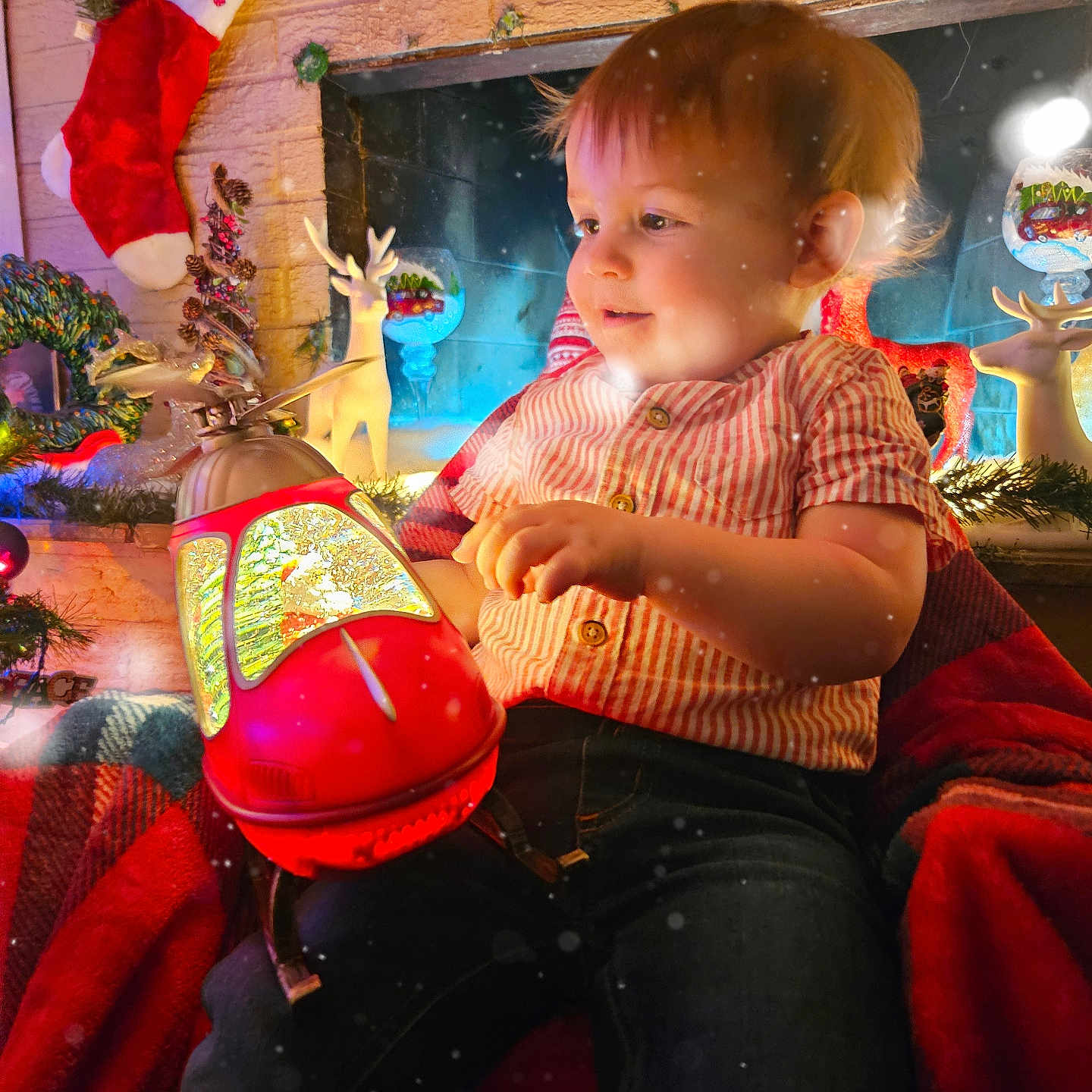 Elton is registered to the contest to win money with this photo: adult, baby, christmas, christmasdecorations, christmasstocking, clothing, couch, face, female, festival, furniture, gift, head, helmet, hosiery, indoors, pants, person, stocking, woman