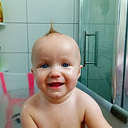 Faustine a rejoint le concours — aidez-le/la à gagner de superbes lots ! baby, bath, bathtub, child, smiling, blue_eyes, moawk, water, skin, indoor, tiled_wall, glass_door, happy, cute, infant, portrait, person, playful, yellow_toy, bathroom