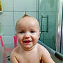 baby, bath, bathtub, child, smiling, blue_eyes, moawk, water, skin, indoor, tiled_wall, glass_door, happy, cute, infant, portrait, person, playful, yellow_toy, bathroom