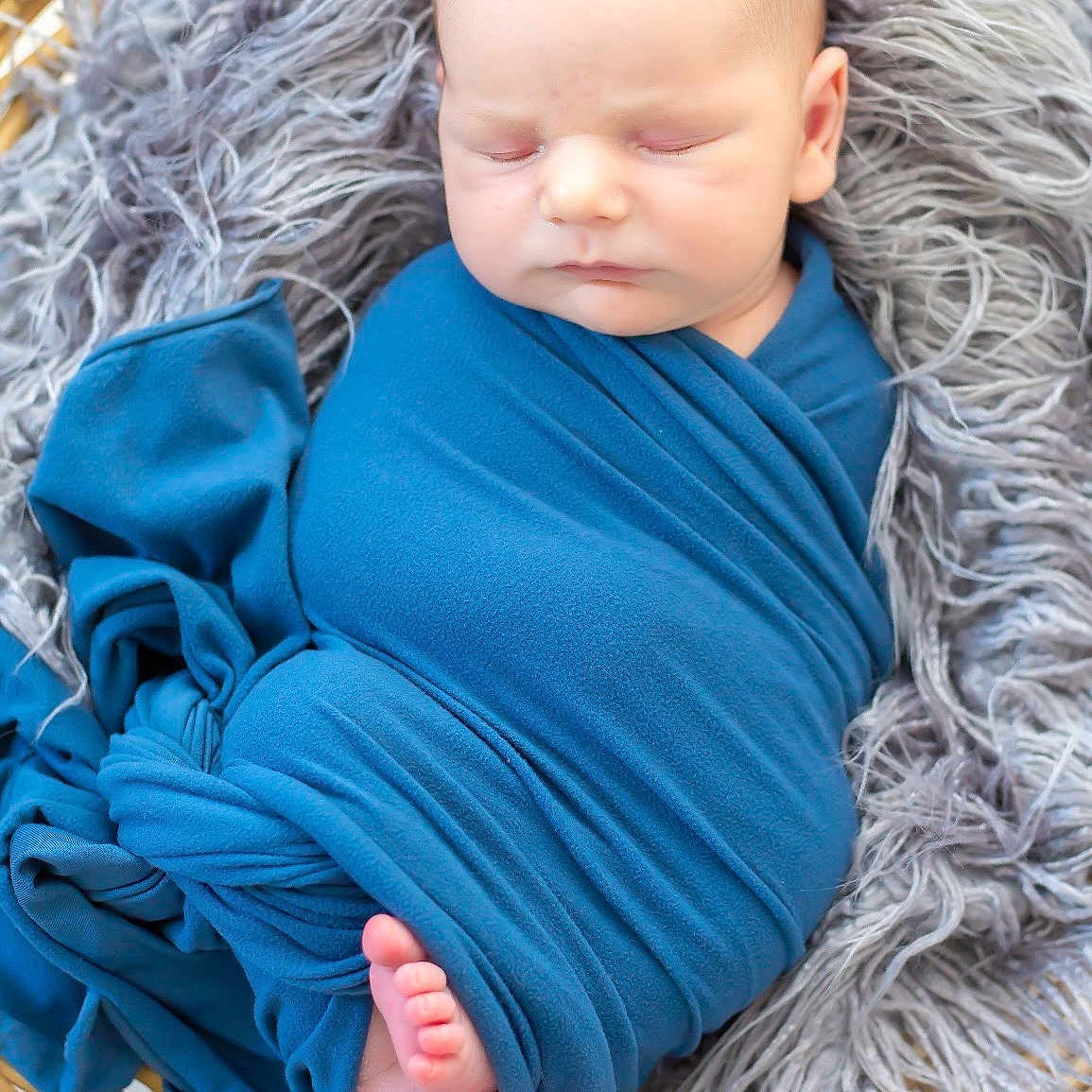 Valentin participe au concours pour gagner de l'argent avec cette photo : baby, newborn, sleeping, blue_blanket, basket, fluffy, gray_fabric, wrapped, peaceful, cute, infant, foot, portrait, indoors, soft_texture, resting, child, closeup, warm, cozy