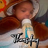 baby, infant, child, sleepy, bottle, feeding, bear_hat, hooded_clothing, blanket, bed, cozy, portrait, face, eyes, indoors, nursery, hearts, colorful, cuddly, text_overlay