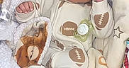 Elias joined the competition — help win amazing prizes! baby, bed, bedding, blanket, close_up, cozy, face, football, fox, hands, indoors, infant, morning, nursery, onesie, pacifier, plush_toy, portrait, sleeping, text_overlay