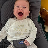 Marius participe au concours pour gagner de l'argent avec cette photo : baby, infant, smiling, laughing, baby_seat, chicco, white_clothing, text_on_clothing, plush_toy, indoor, cute, happy, child, seatbelt, comfort, portrait, human, face, one_person, young_child
