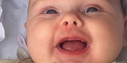 Romi is registered to the contest to win money with this photo: apparel, baby, beads, child, close_up, cute, expression, face, happy, head, indoors, infant, knitted, pacifier, portrait, skin, smiling, soft_light, wooden_star, yellow_clothing