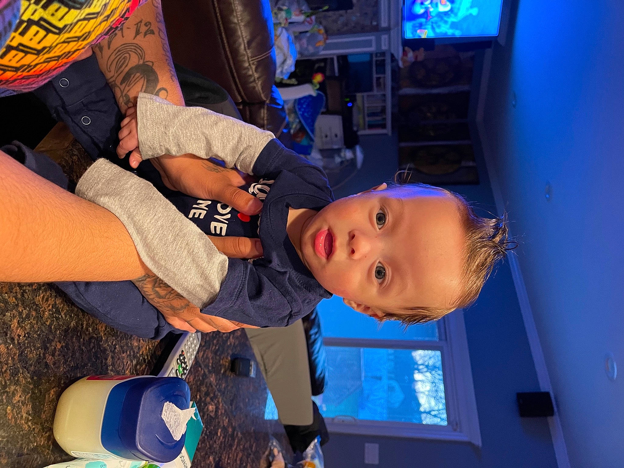 Izayah is registered to the contest to win money with this photo: audio_equipment, baby, blue, child, cloud, cool, elbow, electric_blue, fun, hat, human_leg, leisure, machine, mouth, person, room, t_shirt, television, thigh, toddler