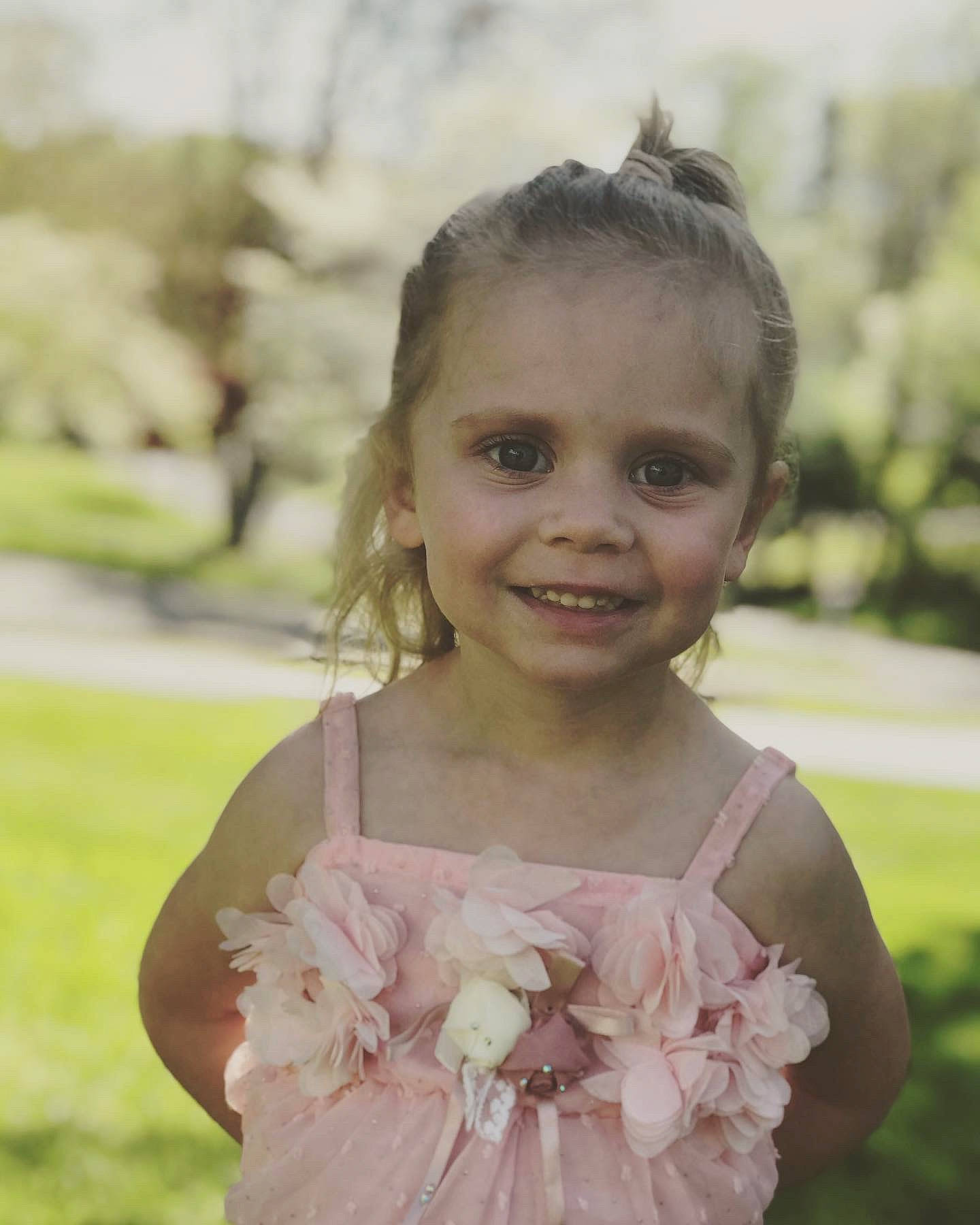 Nevaeh is registered to the contest to win money with this photo: child, dress, face, facial_expression, flower, hair_accessory, hairstyle, happy, joy, person, pink, plant, smile, toddler