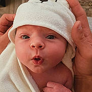 Chesney joined the competition — help win amazing prizes! baby, infant, towel, hood, face, expression, hand, skin, cute, newborn, wrapped, soft, warm, portrait, closeup, child, person, indoors, head, eyes
