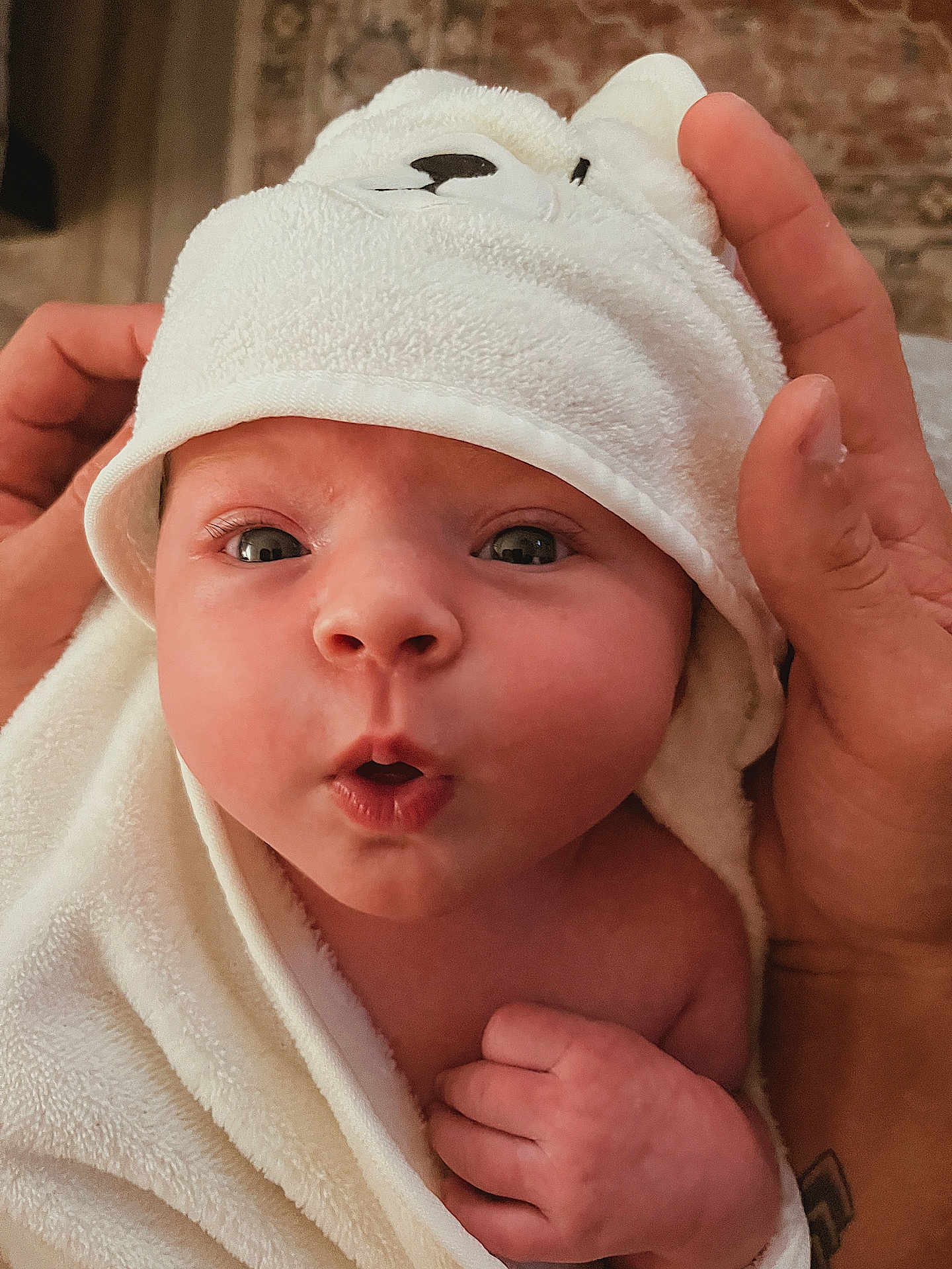 Chesney joined the competition — help win amazing prizes! baby, infant, towel, hood, face, expression, hand, skin, cute, newborn, wrapped, soft, warm, portrait, closeup, child, person, indoors, head, eyes