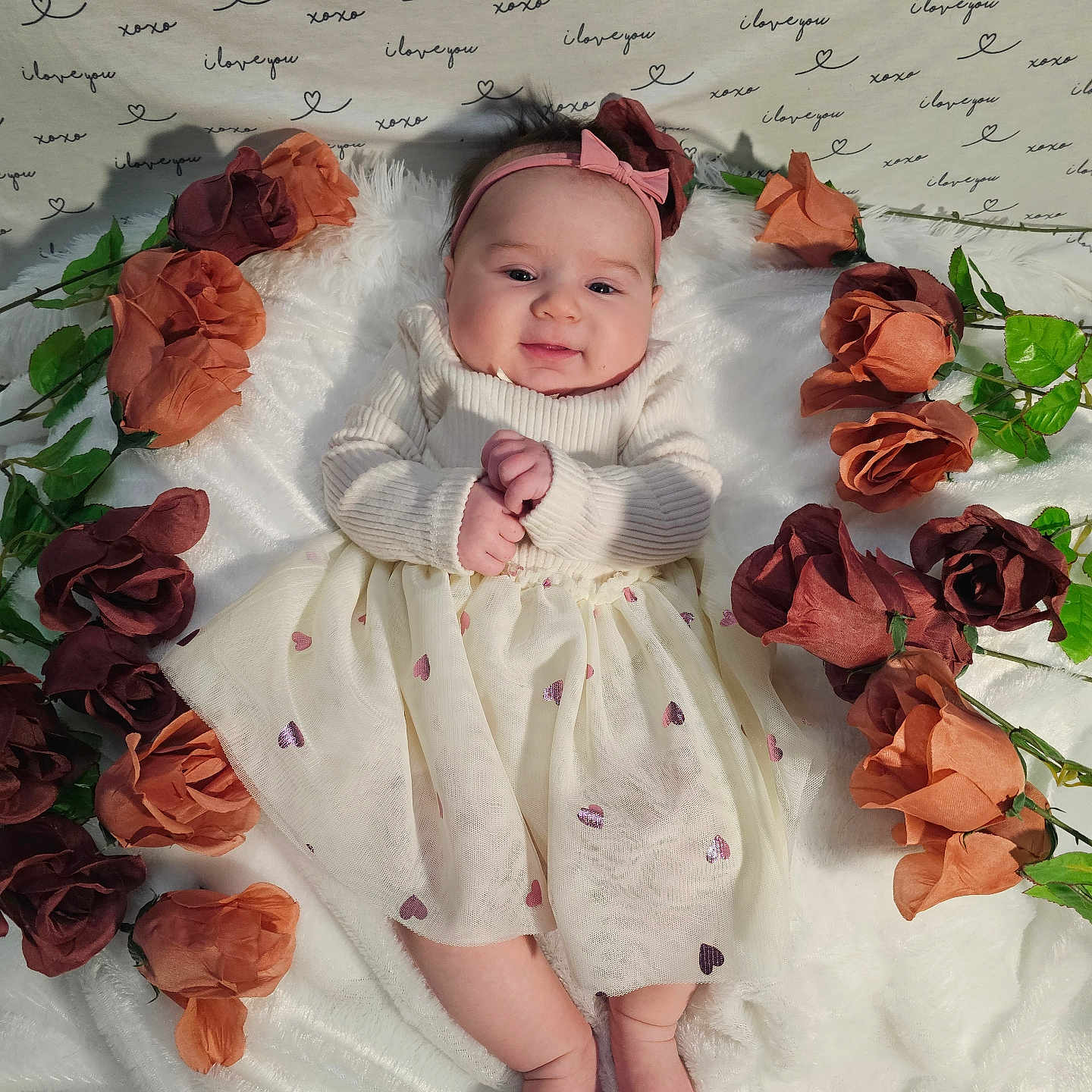Revel is registered to the contest to win money with this photo: baby, bodypart, clothing, dress, face, finger, flower, flowerarrangement, flowerbouquet, hand, hat, head, newborn, person, petal, photography, plant, portrait, rose, text