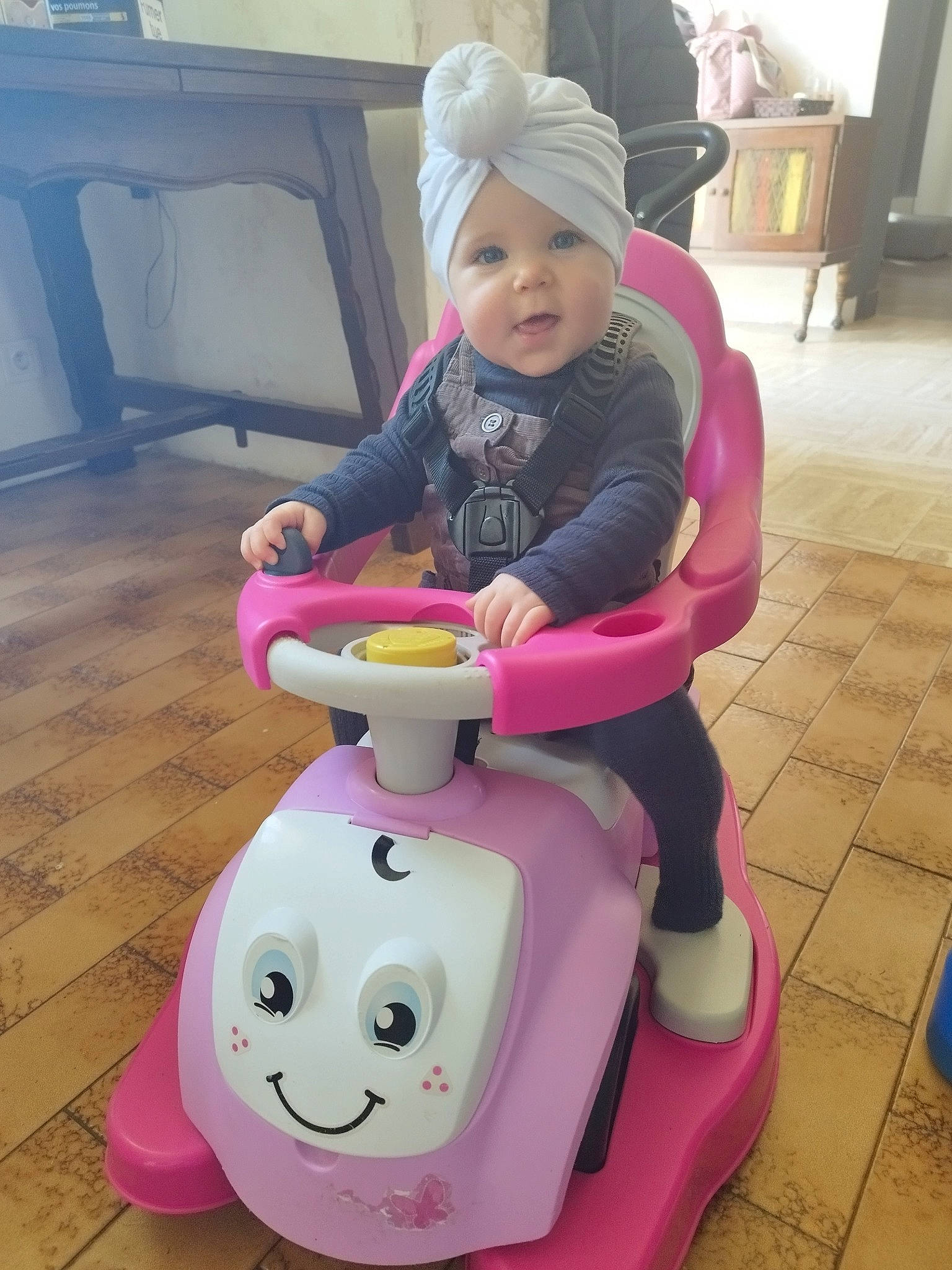 Nayana participe au concours pour gagner de l'argent avec cette photo : baby, baby_carriage, baby_products, baby_toddler_clothing, baby_toys, chair, child, flooring, fun, happy, headwear, lap, magenta, person, pink, purple, recreation, riding_toy, sitting, toddler