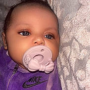 Leighton joined the competition — help win amazing prizes! baby, pacifier, purple_clothing, nike_logo, blue_eyes, infant, close_up, face, pacifier_bow, soft_texture, fabric_background, cute, child, young, portrait, sleepy, indoor, cozy, babywear, calm