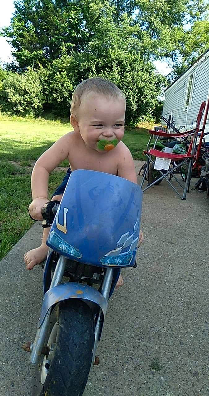 Joshua Hall Jr is registered to the contest to win money with this photo: baby, baby_products, baby_toddler_clothing, chair, child, electric_blue, folding_chair, grass, happy, joy, leisure, outdoor_furniture, person, plant, recreation, sitting, toddler, tree, vacation