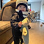 Eden participe au concours pour gagner de l'argent avec cette photo : toddler, child, indoor, plush_toy, hat, scarf, coat, smile, blue_eyes, person, floor, couch, furniture, table, chair, toy, clothing, winter_wear, home, happy